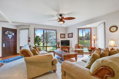 a living room with two couches and a tv at Castle Kanaloa at Kona in Kailua-Kona