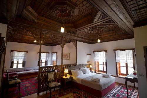 sypialnia z dużym łóżkiem i drewnianym sufitem w obiekcie Hotel Kalemi 2 w Gjirokastrze