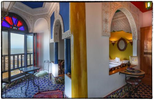 a room with a bedroom with a view of the ocean at Dar Ayour appartements in Essaouira