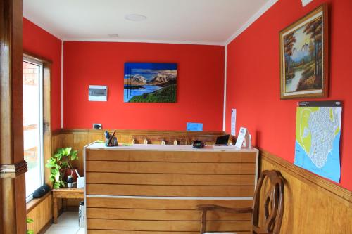 a bathroom with a red wall with a sink at Hostal America en Puerto Natales in Puerto Natales