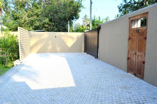 a driveway with a fence and a gate with a door at Kethaka Aga in Tissamaharama