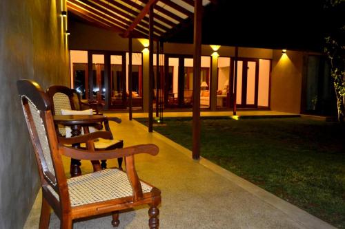 a patio with chairs and a table in a building at Kethaka Aga in Tissamaharama
