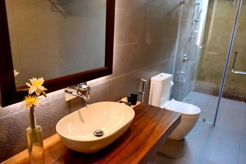 a bathroom with a sink and a shower with a toilet at Kethaka Aga in Tissamaharama