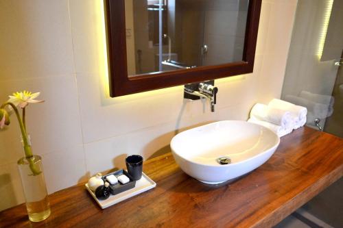 a bathroom with a sink and a mirror on a wooden counter at Kethaka Aga in Tissamaharama