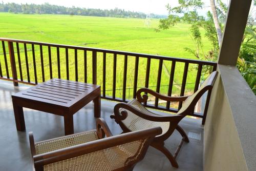 a balcony with a table and two chairs and a table at Kethaka Aga in Tissamaharama