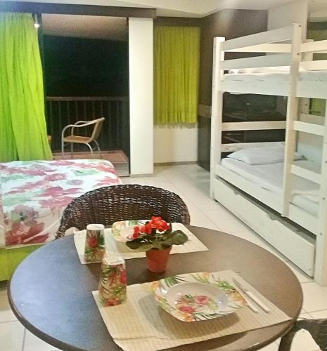 a room with a table and two bunk beds at Marulhos suítes e resorts in Porto De Galinhas