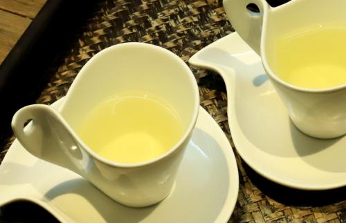 due tazze di tè appoggiate su piatti su un tavolo di Y Resort Jeju a Seogwipo
