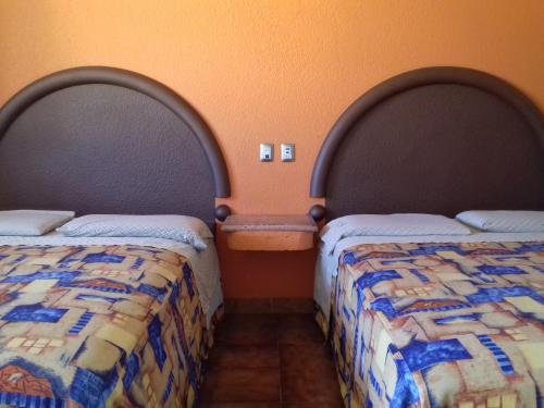 two beds sitting next to each other in a room at Promotora Hotelera Tocuila in Texcoco de Mora
