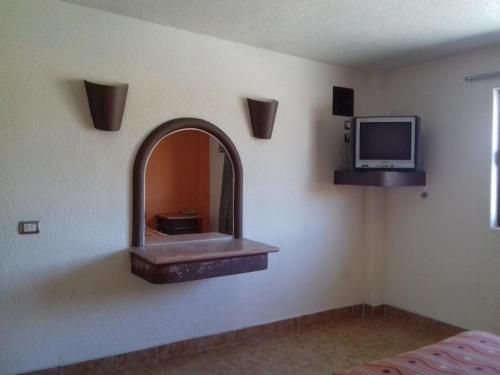 a room with a mirror and a tv on the wall at Promotora Hotelera Tocuila in Texcoco de Mora