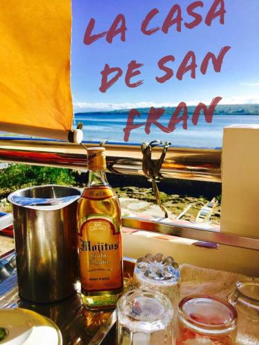 a bottle of whisky sitting on a table next to a window at La Casa de Samonteza in Camotes Islands