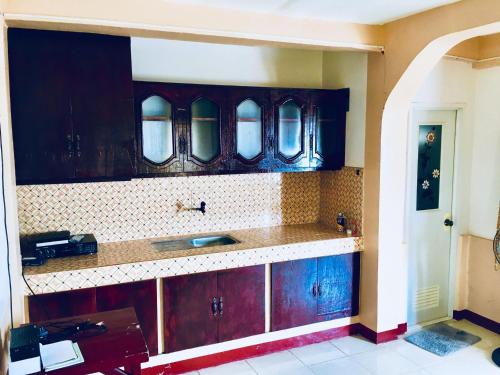 a kitchen with dark wood cabinets and a sink at La Casa de Samonteza in Camotes Islands