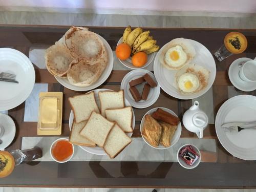 a table with plates of breakfast food on it at The Cool Nest Yala Hotel in Tissamaharama