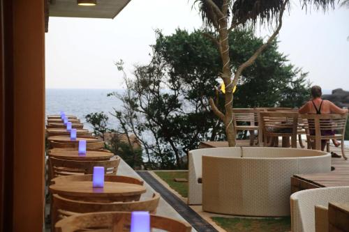a row of tables and chairs with the ocean in the background at Thaproban Pavilion Waves in Unawatuna