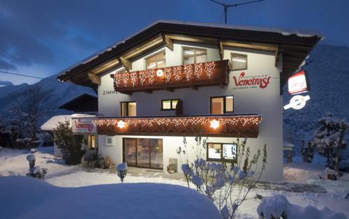 a building with a sign on it in the snow at Gasthof Venetrast in Imsterberg