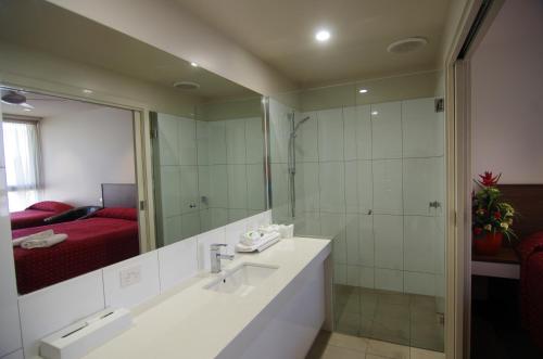 a bathroom with a sink and a large mirror at Jane Eliza Motor Inn in Swan Hill