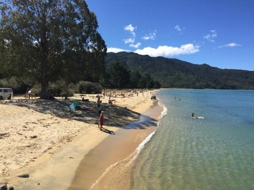 a group of people on a beach in the water at Abel Tasman Marahau in Marahau