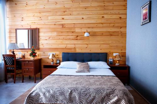 a bedroom with a bed and a wooden wall at Abazhur Hotel in Tomsk