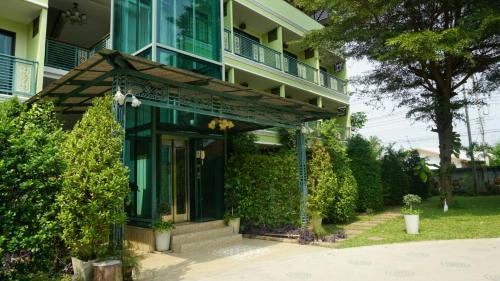 dom z zielonymi drzwiami wejściowymi i werandą w obiekcie Garden Corner Resort & Hotel w mieście Phitsanulok