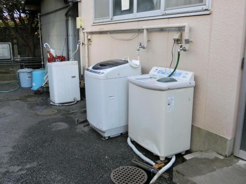 a group of old washing machines sitting next to a building at Suzukisou in Kyoto