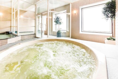 a large bath tub filled with water in a room at Hotel Hanshin Osaka in Osaka