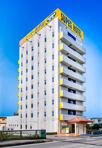 a white building with a super hotel sign on it at Super Hotel Okinawa Nago in Nago