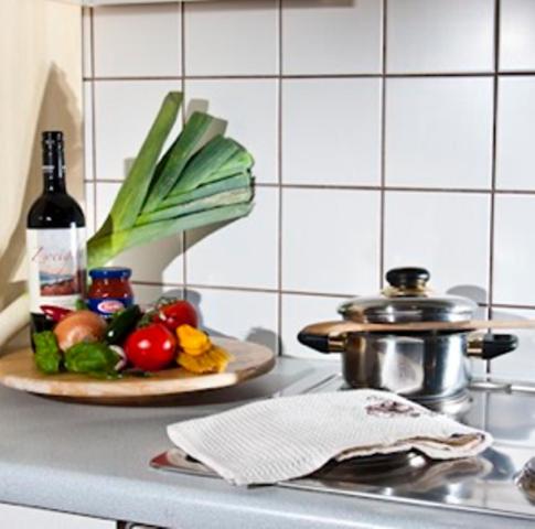 a kitchen counter with a plate of vegetables and a bottle of wine at Appartement Heidehof in Längenfeld