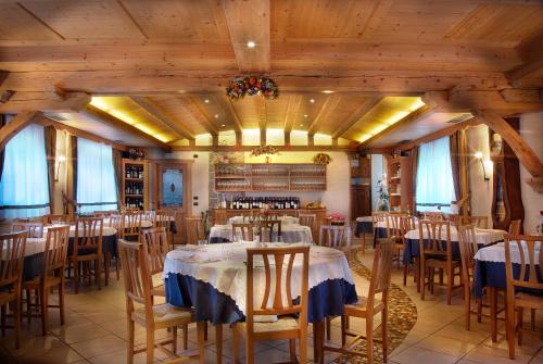 a dining room with tables and chairs and wooden ceilings at Albergo Ristorante Alle Codole in Canale dʼAgordo
