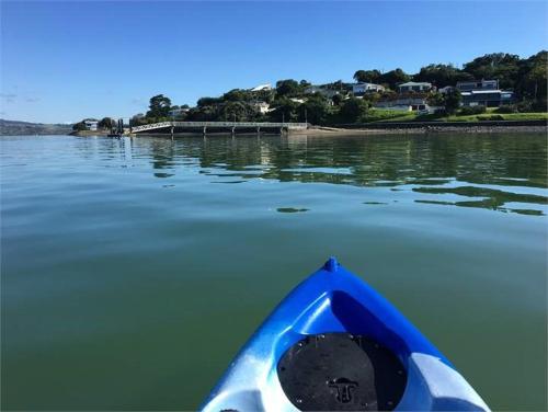 a blue kayak in the water near a dock at Mason lane Apartment in Whangarei