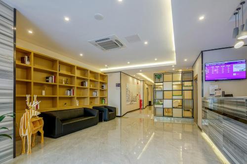 a lobby with a couch and a tv in a building at Yimi Inn Changdi Damalu Branch in Guangzhou