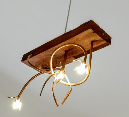 a metal and wood pendant light hanging from a ceiling at Casa della Nonna Polignano a mare in Polignano a Mare