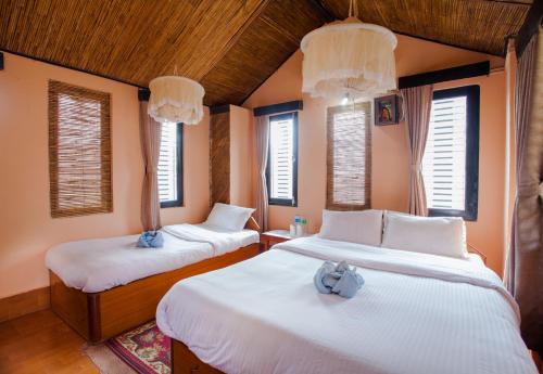 Postel nebo postele na pokoji v ubytování Chitwan Tiger Camp