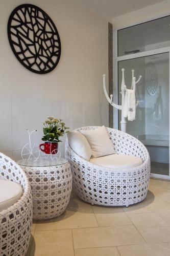 a room with two wicker chairs and a table at Pousada D'Biagy Premium in Campos do Jordão