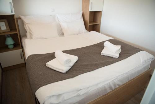 a bedroom with a bed with white towels on it at Glamping Sun Valley Bioterme in Mala Nedelja