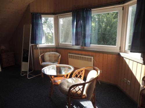 a room with a table and chairs and windows at Feriendorf Klosterheide in Lindow