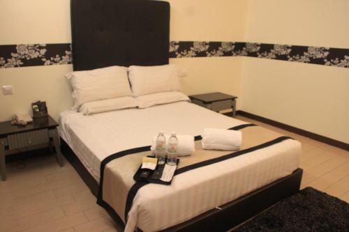 a bedroom with a bed with two towels on it at Shervinton Executive Boutique Hotel in Tawau