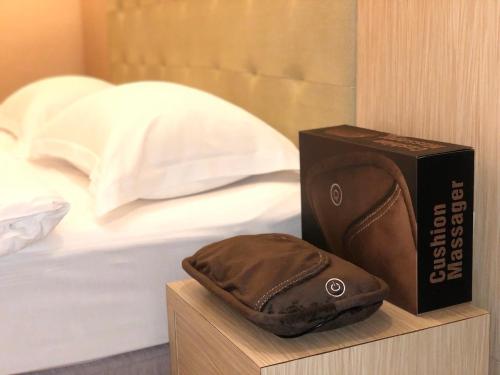 a hat sitting next to a box next to a bed at The Riverside Hotel Hengchun in Hengchun