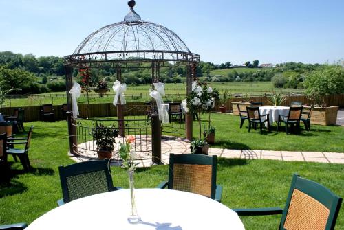 an outdoor wedding with a gazebo and tables and chairs at The Old Barn Inn in Newport