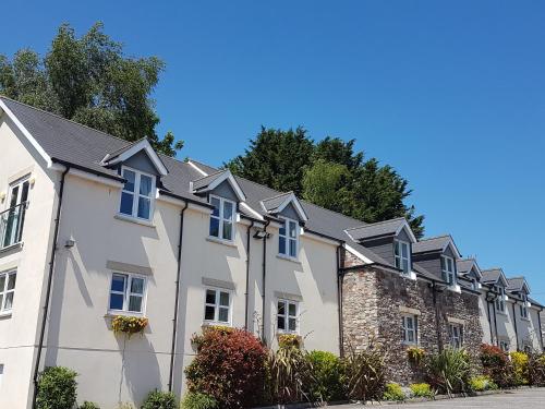 uma fila de casas brancas com telhados pretos em The Old Barn Inn em Newport