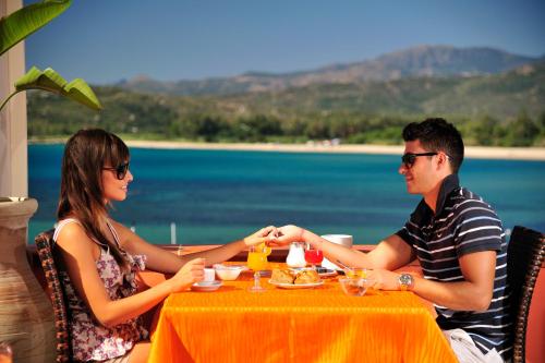 a man and a woman sitting at a table at Hotel Club Saraceno - Bovis Hotels in Àrbatax