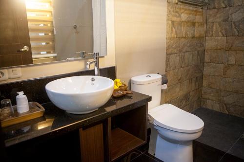 a bathroom with a white sink and a toilet at Villa Sawah Resort Managed by Salak Hospitality in Bogor