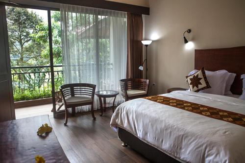 a hotel room with a bed and a balcony at Villa Sawah Resort Managed by Salak Hospitality in Bogor