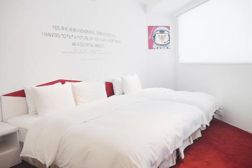a large white bed with white pillows in a room at Time Flyer Hotel in Taichung