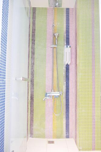 a bathroom with a shower with colorful tiles at Time Flyer Hotel in Taichung
