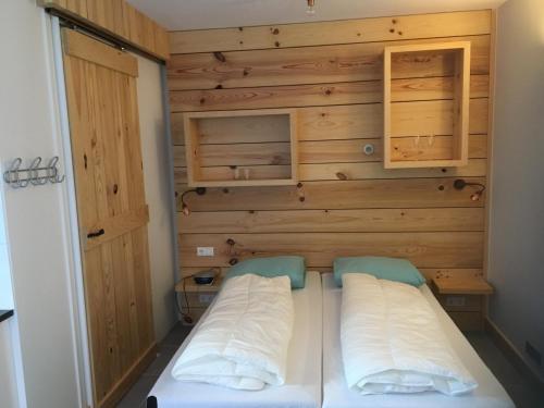 ドンブルグにあるStudio voor 2 personenの木製の壁のドミトリールームのベッド1台分です。