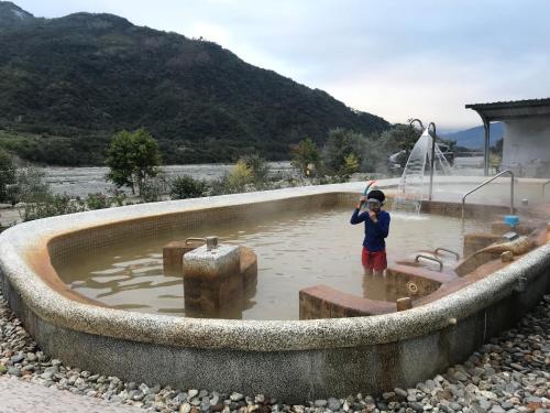 a young boy standing in a water fountain at Jin Ping Homestay in Haiduan