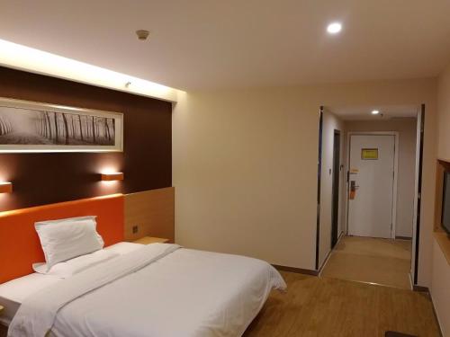 7Days Premium Zhengzhou Jingsan Road Century Lianhua في تشنغتشو: غرفة نوم بسرير ابيض كبير وممر