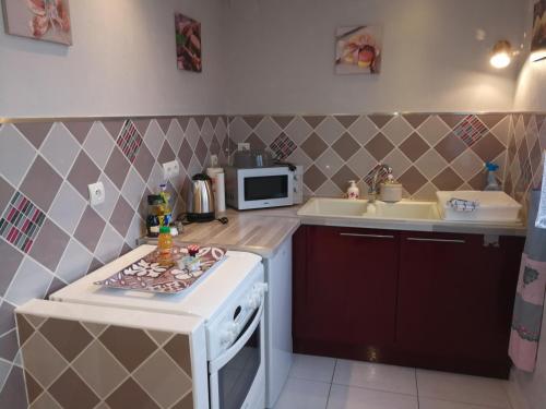 a small kitchen with a stove and a microwave at Comme chez vous in Ruelle-sur-Touvre