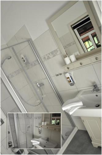 a bathroom with two sinks and a mirror at Café im Hof- Bed & Breakfast in Streufdorf