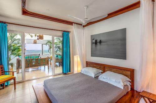 a bedroom with a bed and a view of the ocean at Tequila Sunrise Beach Cabana - Diani Beach in Diani Beach