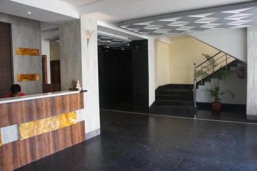 a lobby of a building with a staircase and a person at The Loft Hotel, Siliguri in Siliguri
